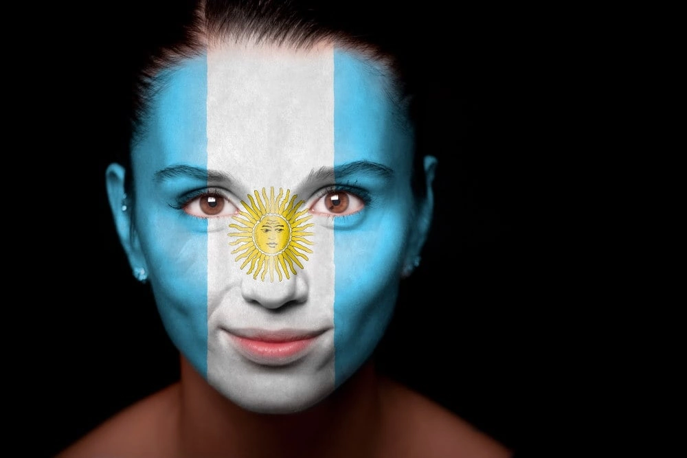 Argentinian woman face painted with the flag of Argentina