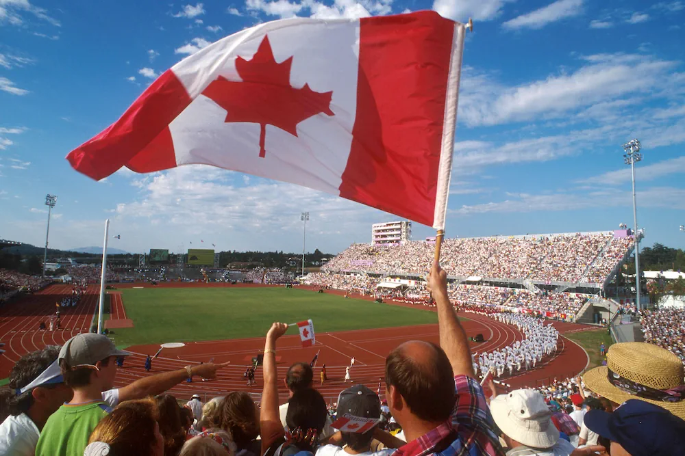 Canadian flag with football field in background