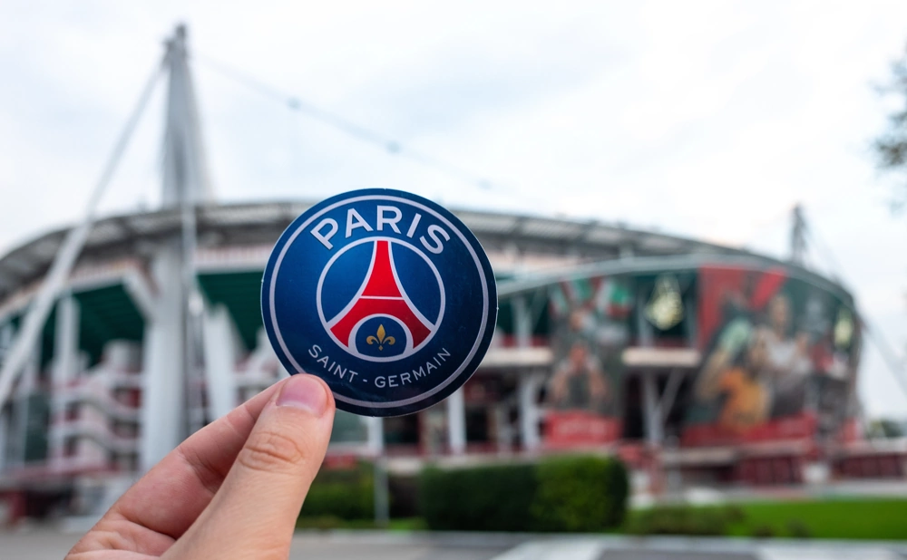 Paris Saint-Germain logo with stadium background