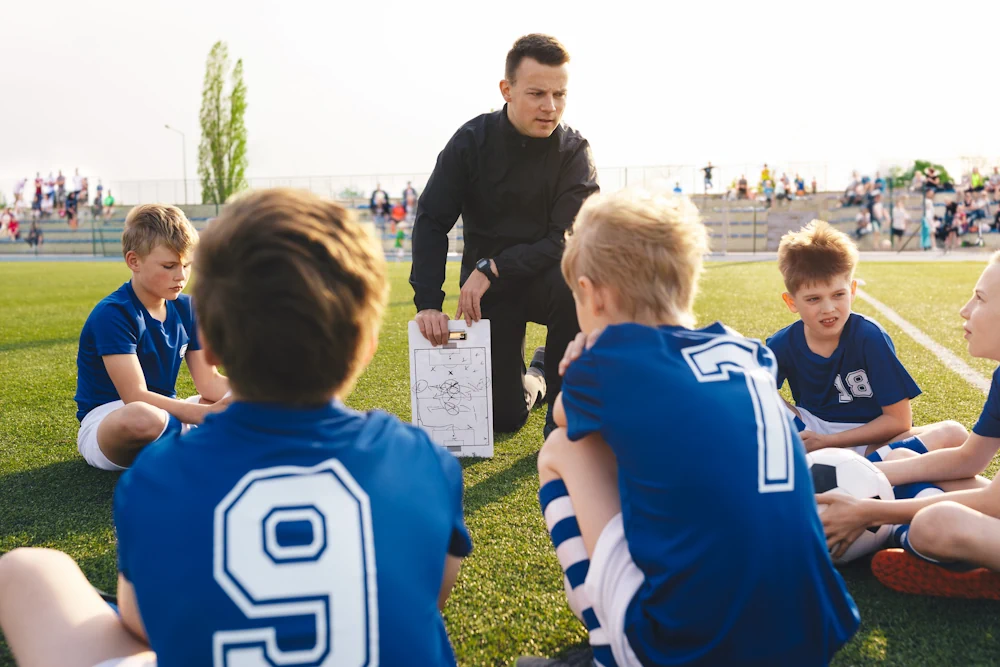 Child football coach teaching child football players strategies