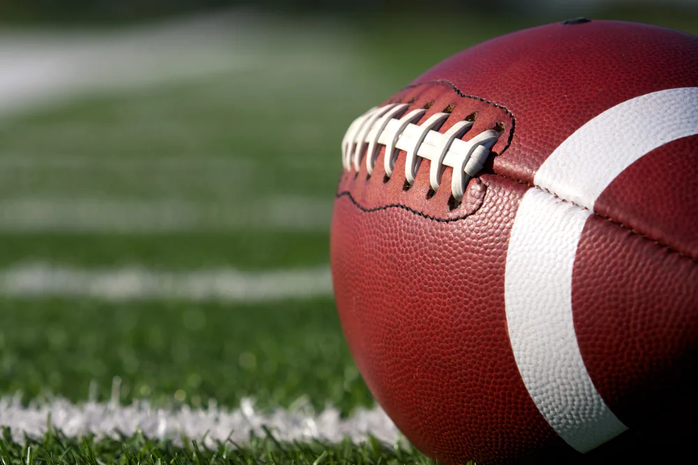 American football lying resting on the field